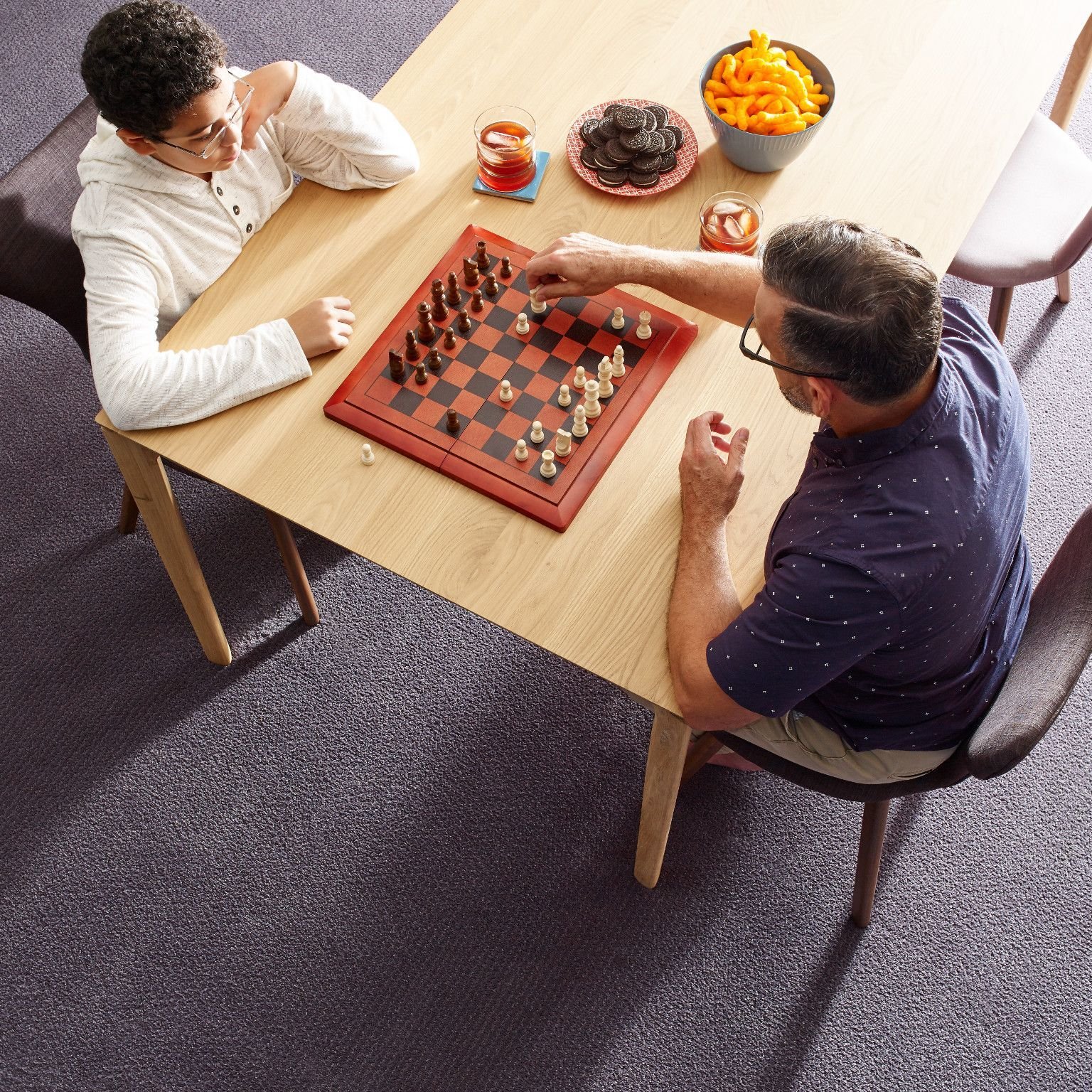 people playing chess at a table in a room with purple carpet from Life Style Floors in Chagrin Falls